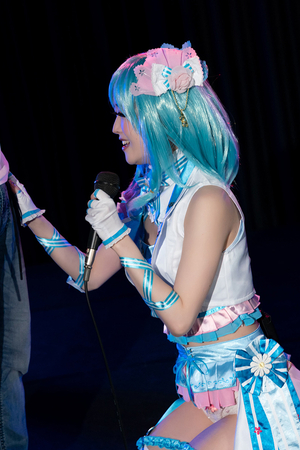 Japanese cosplayer Ria Kurumi sings into a microphone and does a blowjob on stage